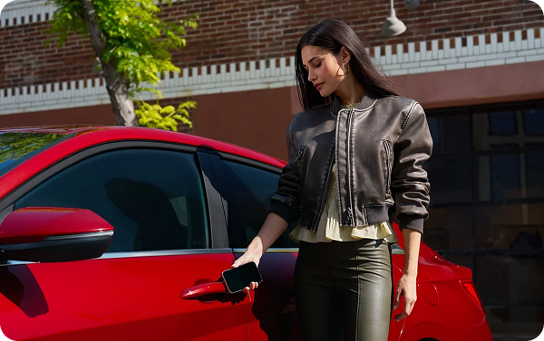 Woman using smartphone to unlock red Hyundai Elantra with Digital Key