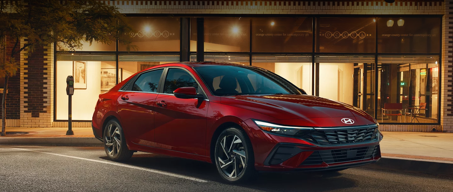 2026 Hyundai Elantra in vibrant red color parked on a city street at night