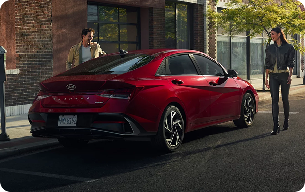 Couple walking towards red Hyundai Elantra using Digital Key on smartphone
