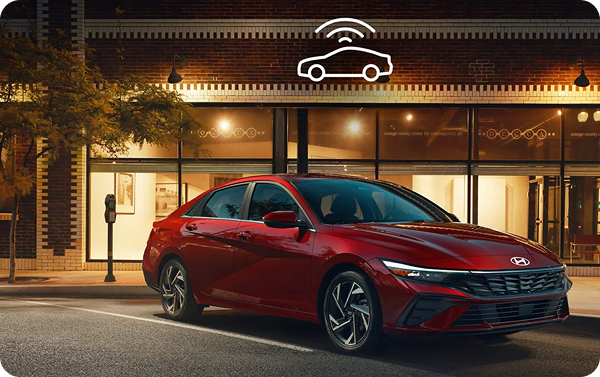 Red Hyundai Elantra at night with Wi-Fi connectivity icon above