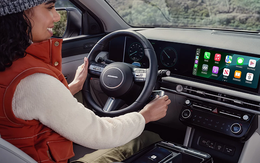 Woman driving 2026 Hyundai Tucson Hybrid with Apple CarPlay