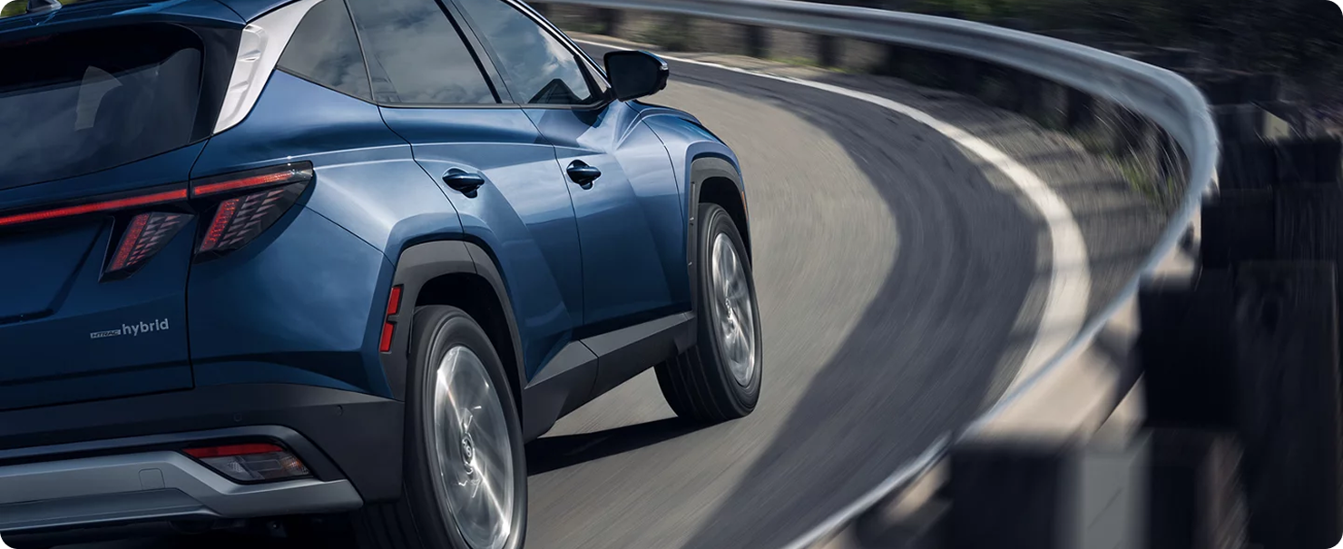 2026 Hyundai Tucson Hybrid driving on curved road