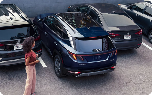 Woman using Remote Smart Parking Assist with Tucson Hybrid