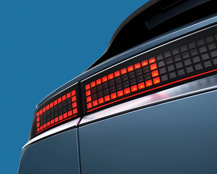 The glowing red pixel taillight on the rear of a blue IONIQ 5