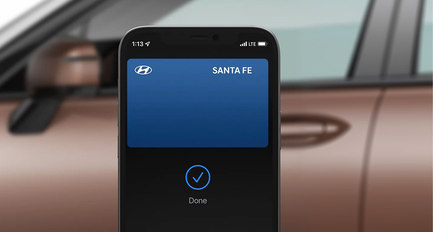 A smartphone held beside a SANTA FE door handle showing the unlock confirmation