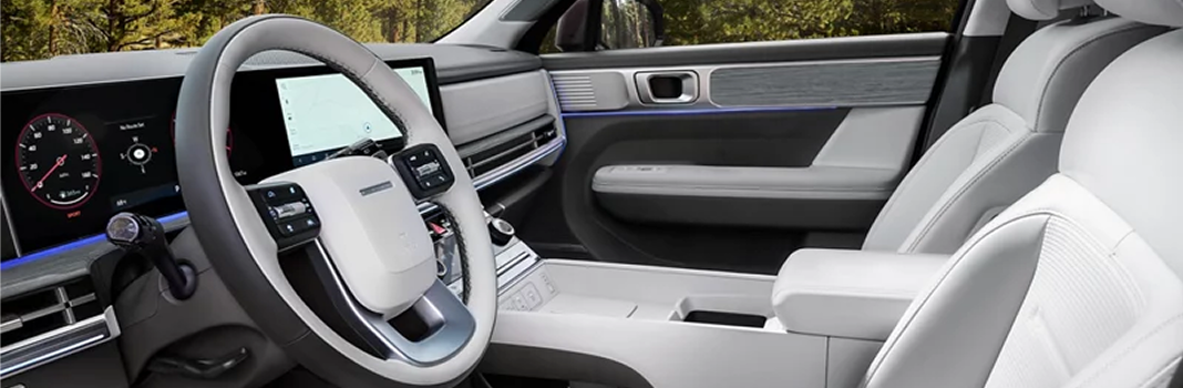 The SANTA FE steering wheel, digital cluster and light gray front seats