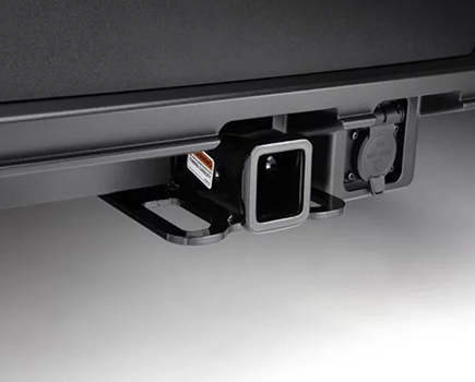 A tow hitch receiver under the rear bumper of a SANTA FE