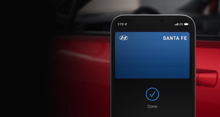 A smartphone held beside a SANTA FE Hybrid door handle showing the unlock confirmation