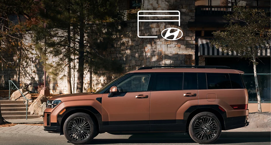 A copper SANTA FE Hybrid parked outside a lodge with a credit card icon above it