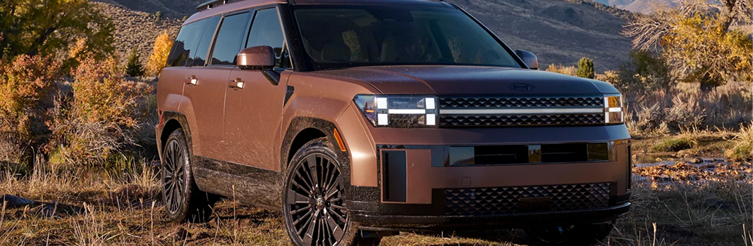 A copper SANTA FE Hybrid parked in autumn brush