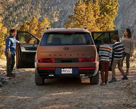 A family loading a copper SANTA FE Hybrid with its doors open