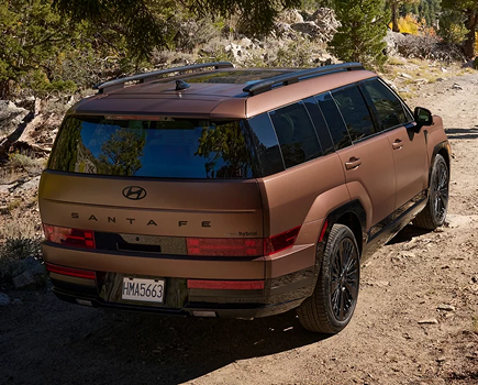 Rear three-quarter view of a copper SANTA FE Hybrid on gravel