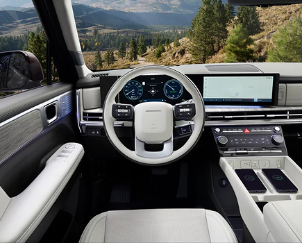 The SANTA FE Hybrid steering wheel and displays with a mountain view ahead