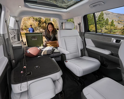 A woman relaxing in the folded-flat cargo area of a SANTA FE Hybrid