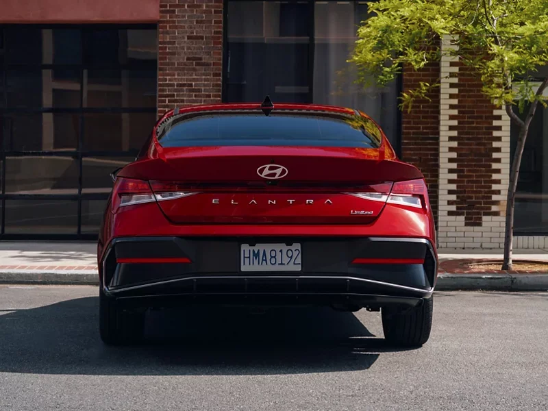 Rear view of a red 2026 Hyundai Elantra parked on a city street, sold and serviced at Dalton Hyundai National City, CA