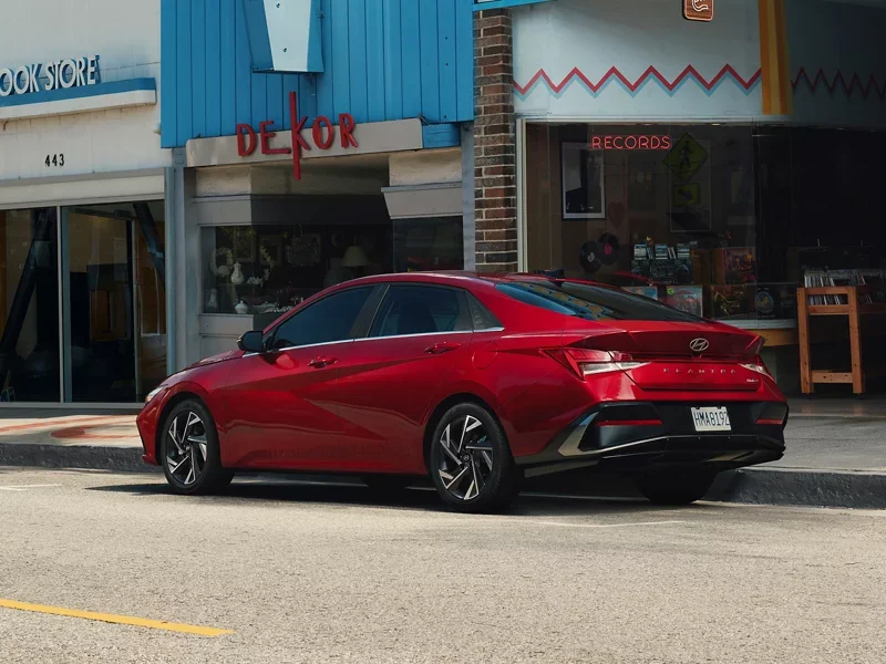 Red 2026 Hyundai Elantra parked on a retro storefront street, the kind of everyday setting it fits into around National City