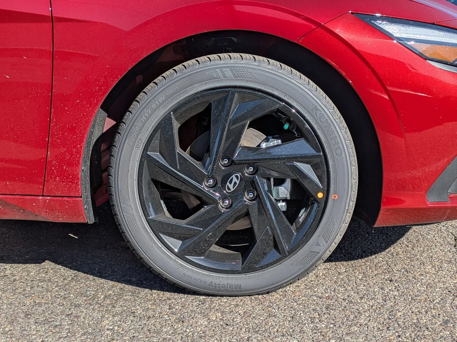 Close-up of the alloy wheel on a red 2026 Hyundai Elantra