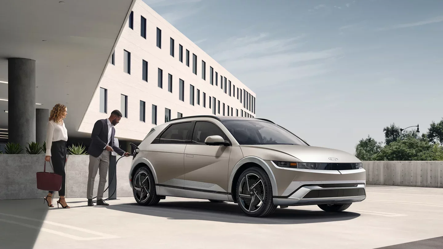 2026 Hyundai IONIQ 5 electric SUV charging outside a modern building, available to lease at Dalton Hyundai National City, CA