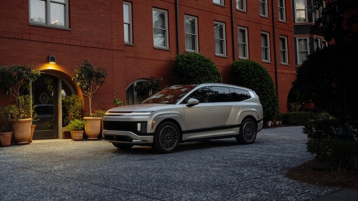 A Hyundai IONIQ 9 three-row electric SUV parked in a residential driveway at dusk