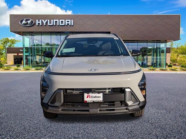 A sand-colored Hyundai Kona photographed head-on outside the Dalton Hyundai National City showroom