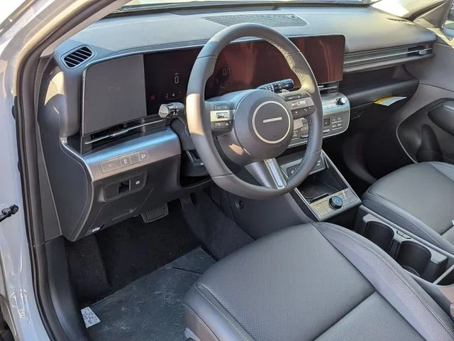 The Hyundai Kona driver's area seen from the passenger side, with the steering wheel and twin displays