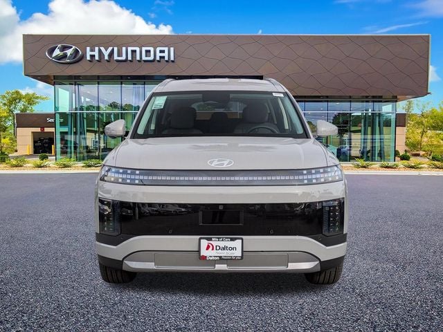 A white Hyundai IONIQ 9 parked head-on outside the Dalton Hyundai National City showroom
