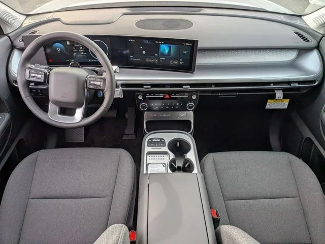 The full IONIQ 9 dashboard viewed head-on, with one curved pane spanning both screens